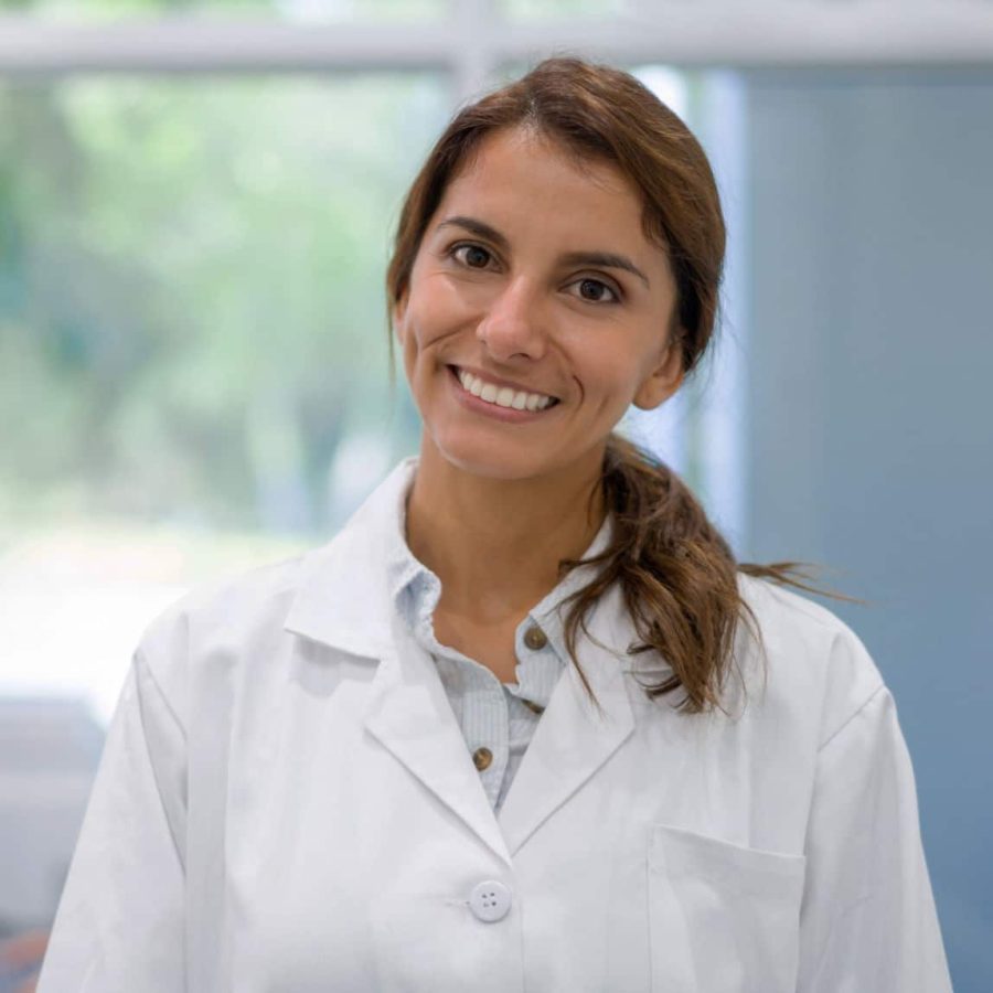 Portrait of a very happy Latin American female doctor smiling at her office and looking at the camera